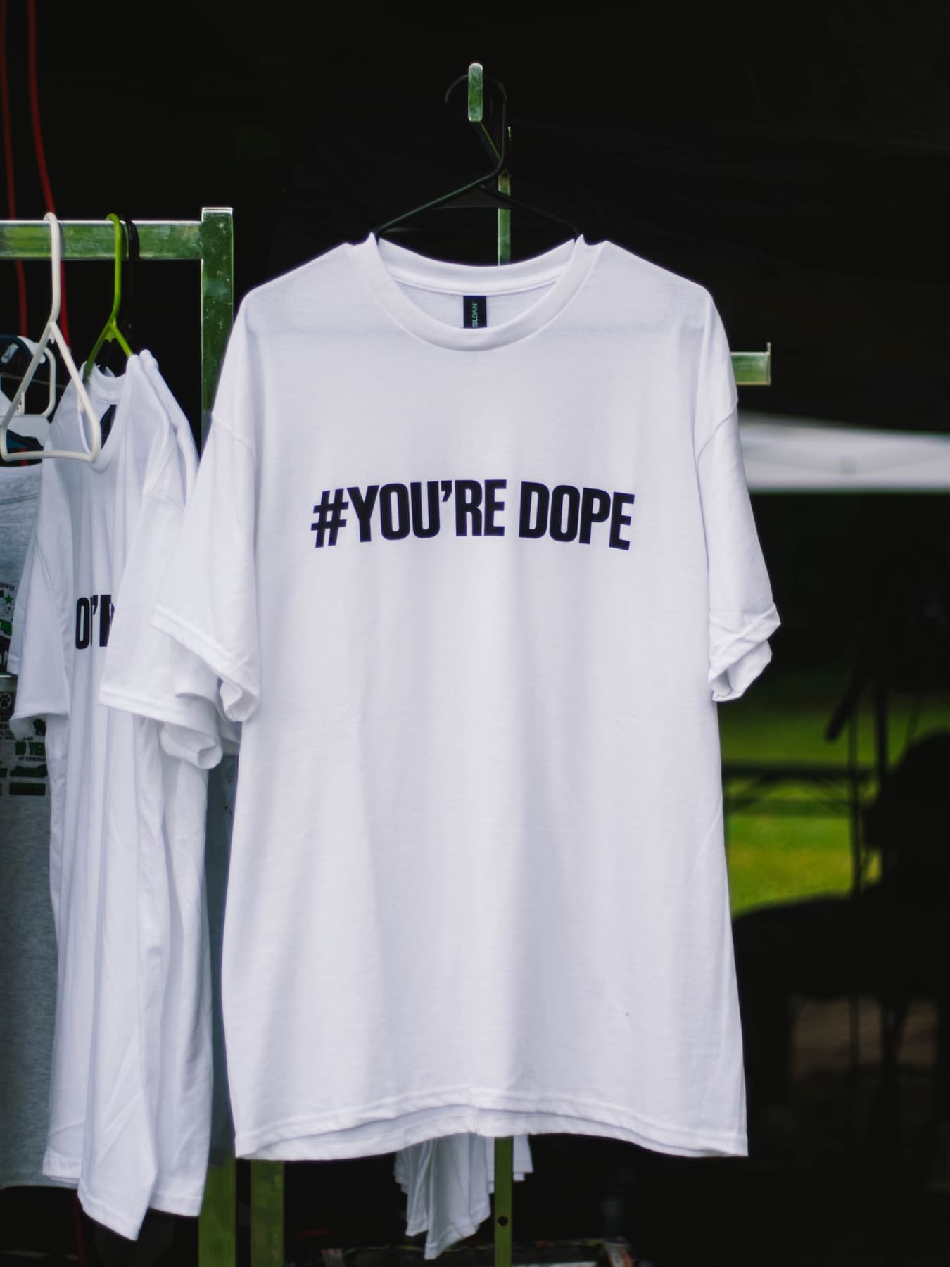 White t-shirt on a hanger printed with #YOU’RE DOPE
